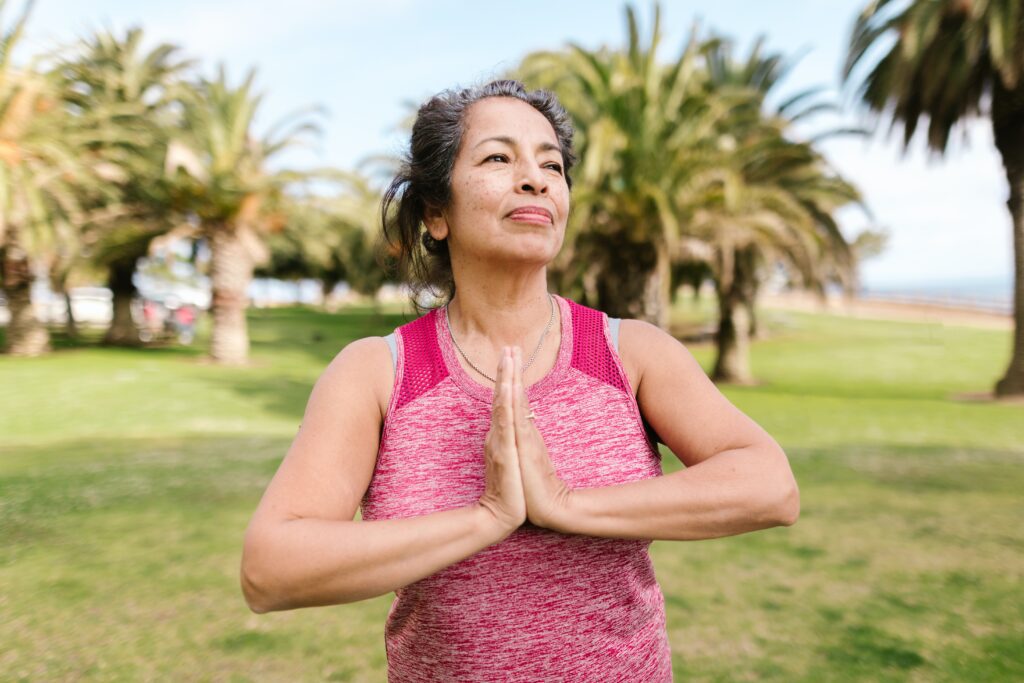 Qualidade de Vida Mulher ao ar livre em posição de paz